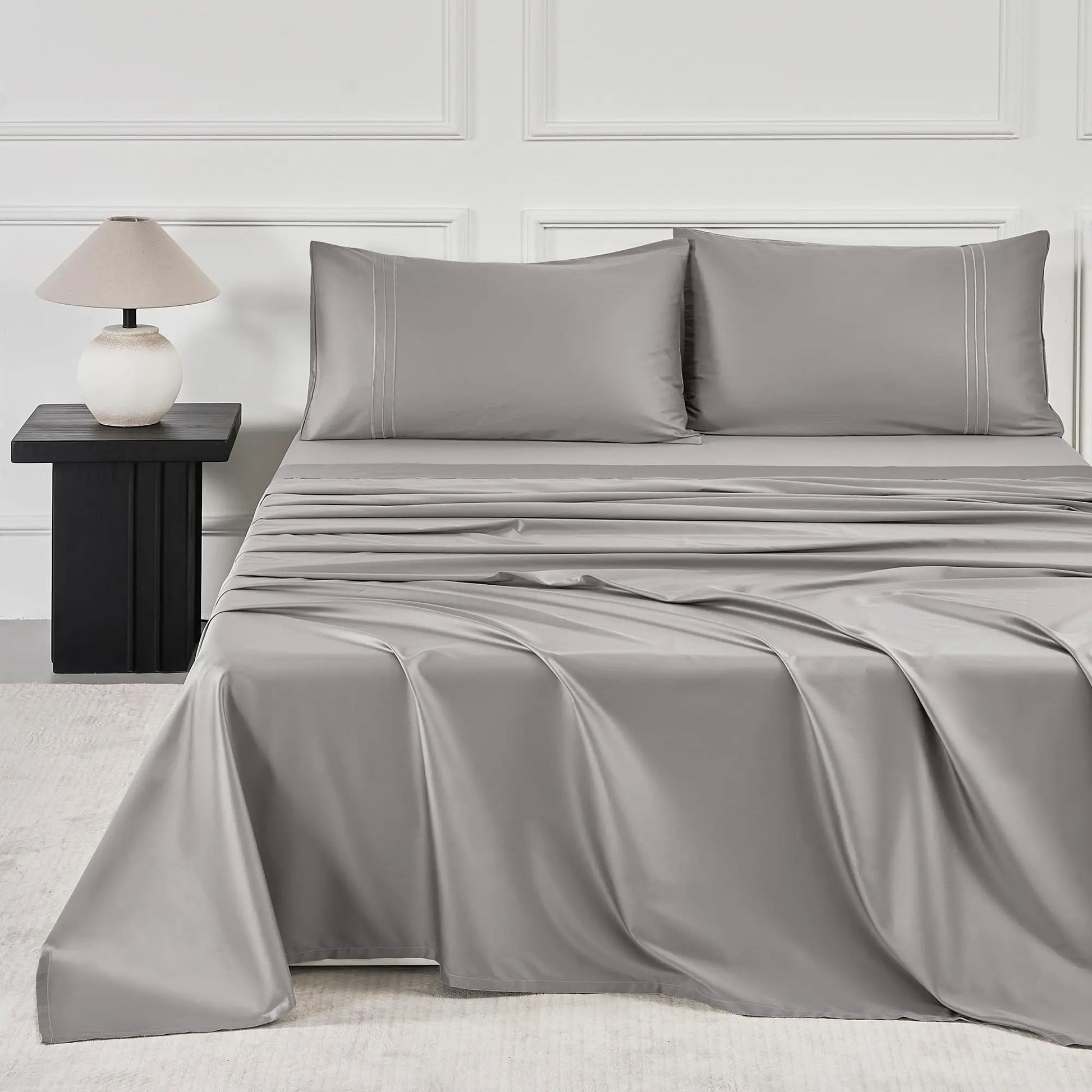 JELLYMONI Soft Cool Cotton Sateen Sheets in a stylish gray color, elegantly spread across a bed with matching pillows and modern bedside lamp.