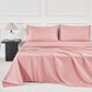 JELLYMONI Soft Cool Cotton Sateen Sheets in a lovely pink shade, showcasing a cozy bed setup complete with plush pillows and a stylish lamp.