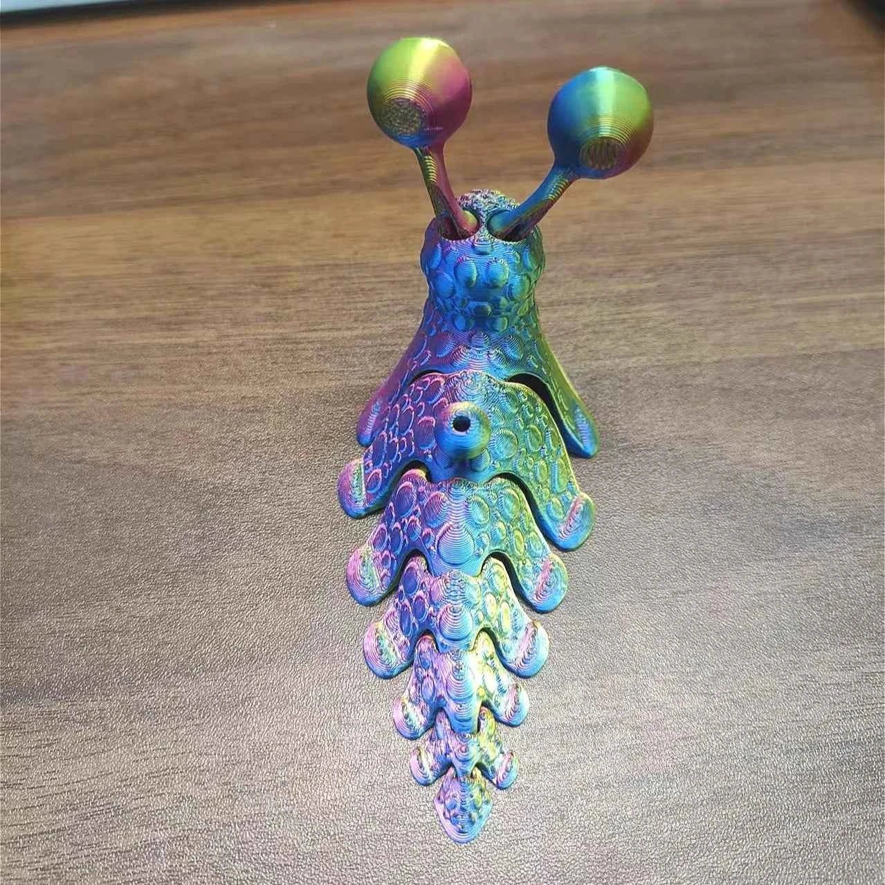 Colorful articulated 3D printed snail toy with detailed features and vibrant patterns